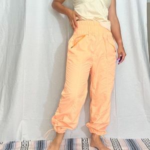 Pale orange neon nylon pants